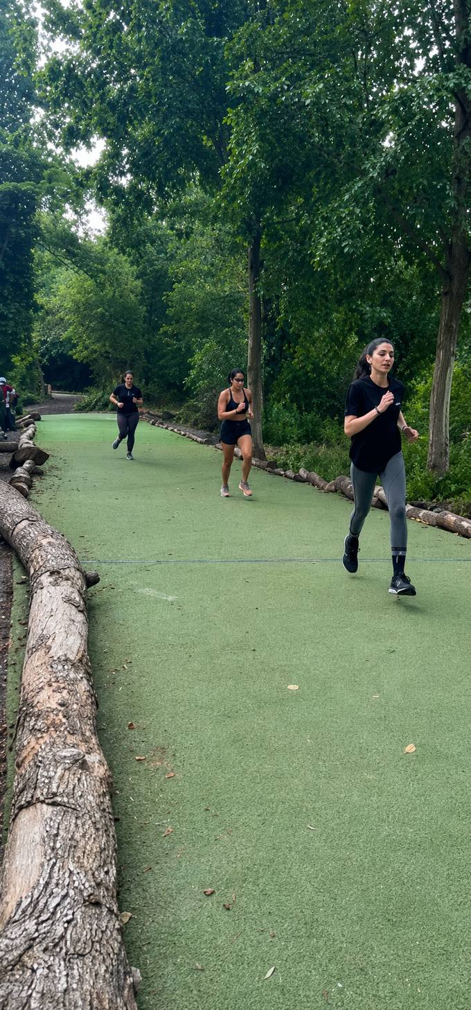 Members on a group trail run through the woods