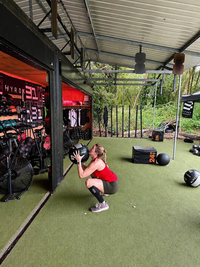 Wall-ball training under the canopy at the HYROX partner gym